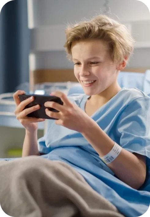 kid playing on his phone while in treatment